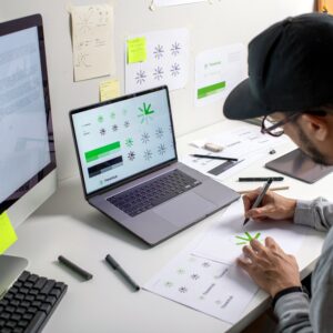 Asian,Graphic,Designer,Making,Notes,On,Logo,Designs,,Using,Computers,